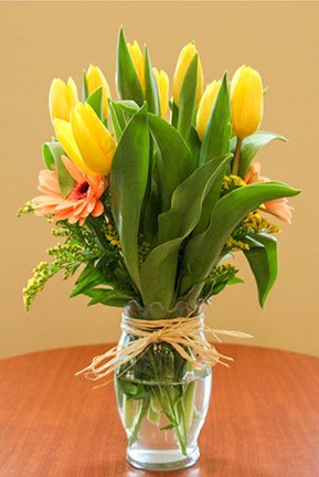 tulip and gerber daisy flower arrangement in a vase