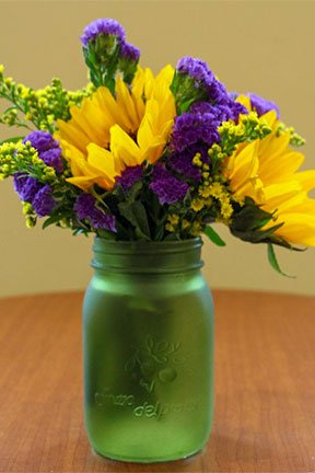sunflowers and assorted flowers in a green mason jar 