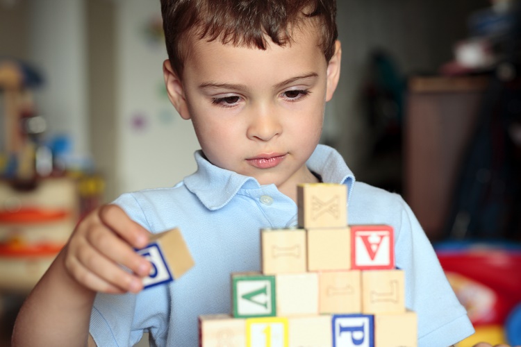 Child with autism playing blocks